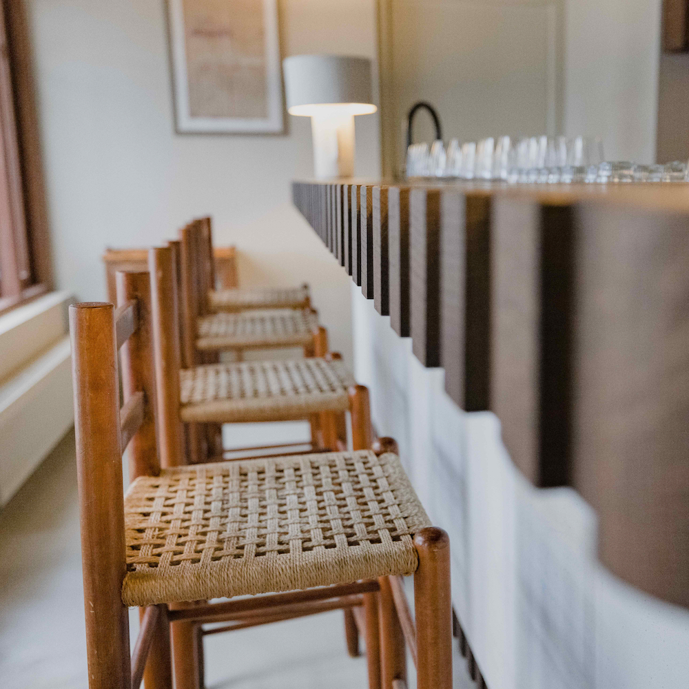 Bar mit Barhockern mit Korbsitz.