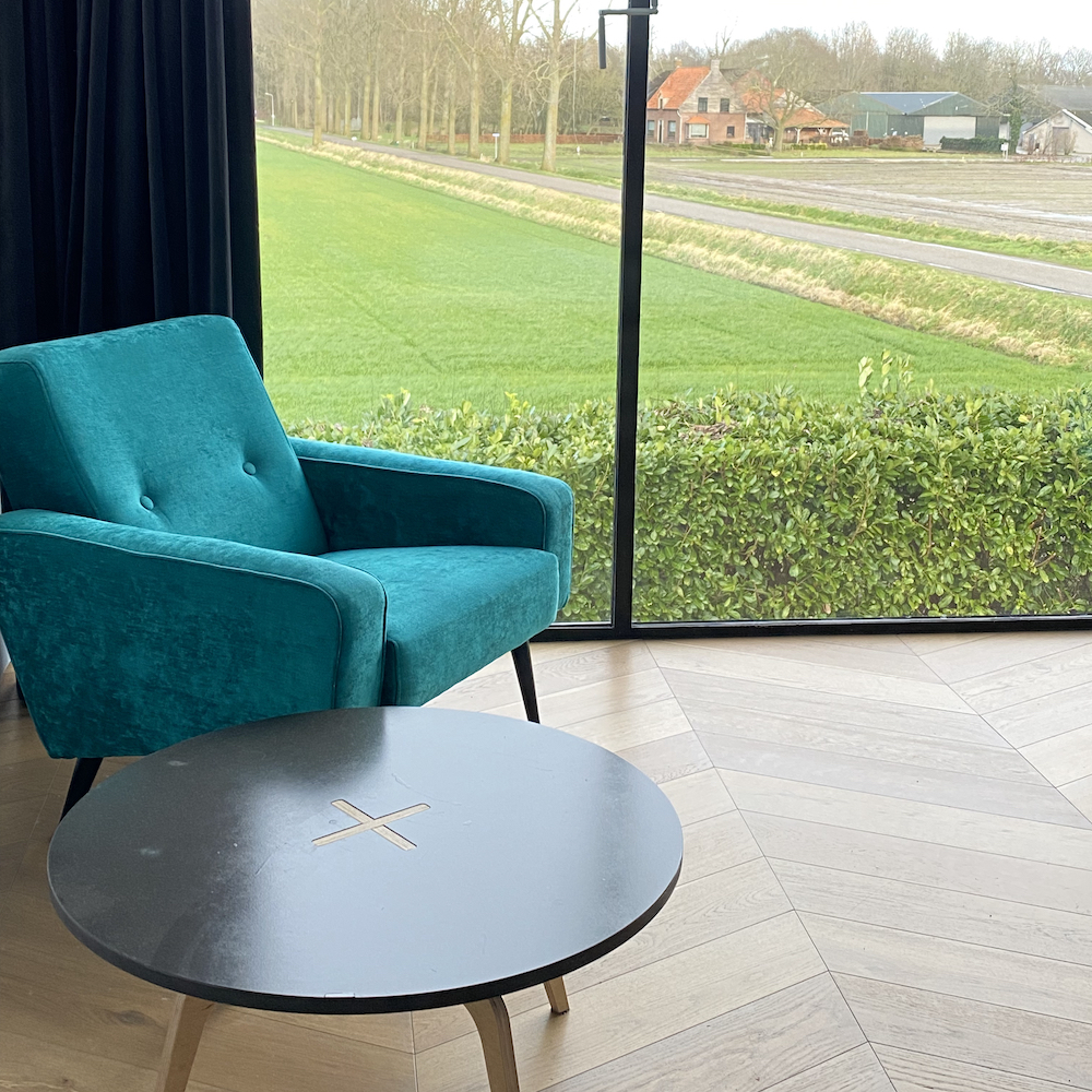 Blauer Sessel vor dem großen Fenster im B&B