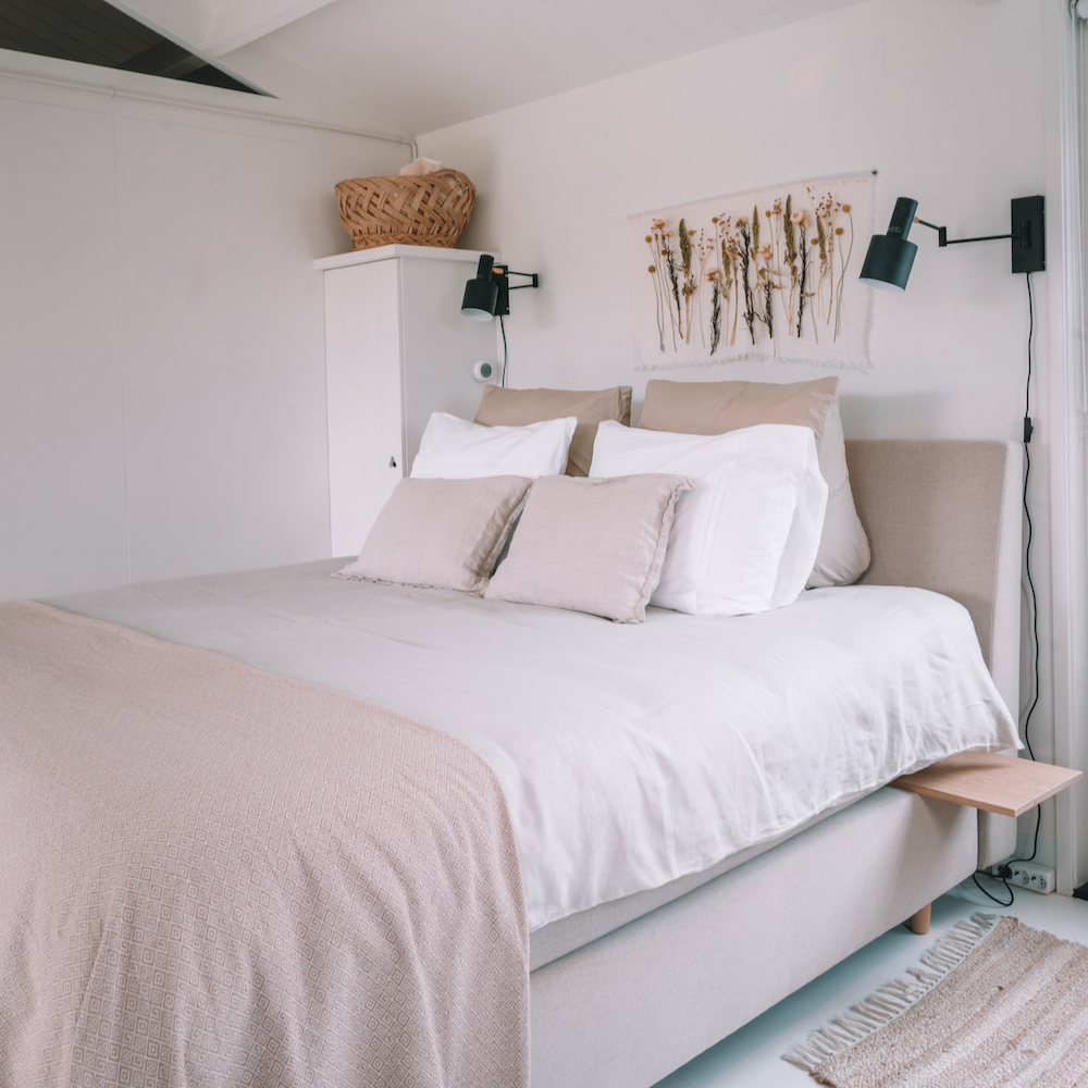 Gemachtes Bett mit weicher, farbiger Bettwäsche