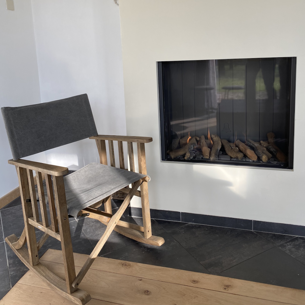 Atmosphärischer Kamin mit Schaukelstuhl neben dem Kamin
