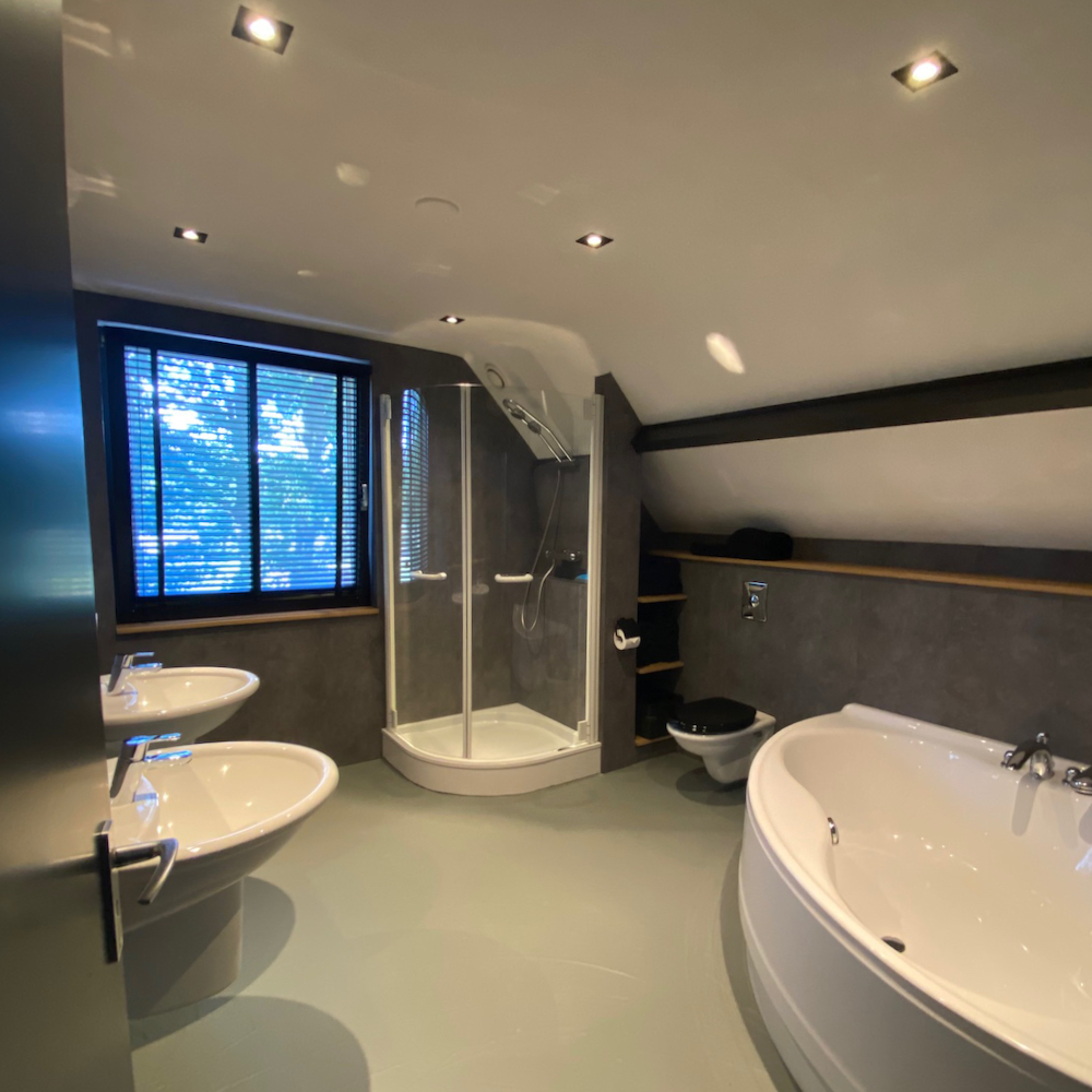 Badezimmer mit Badewanne und Dusche in der Villa