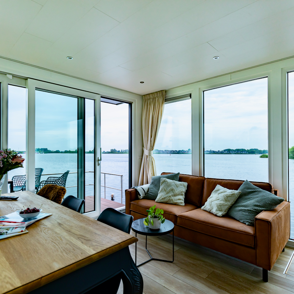 Wohn- und Essbereich vor großen Fenstern