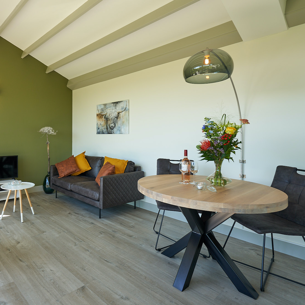 Essecke mit rundem Tisch und Sitzecke mit braunem Ledersofa
