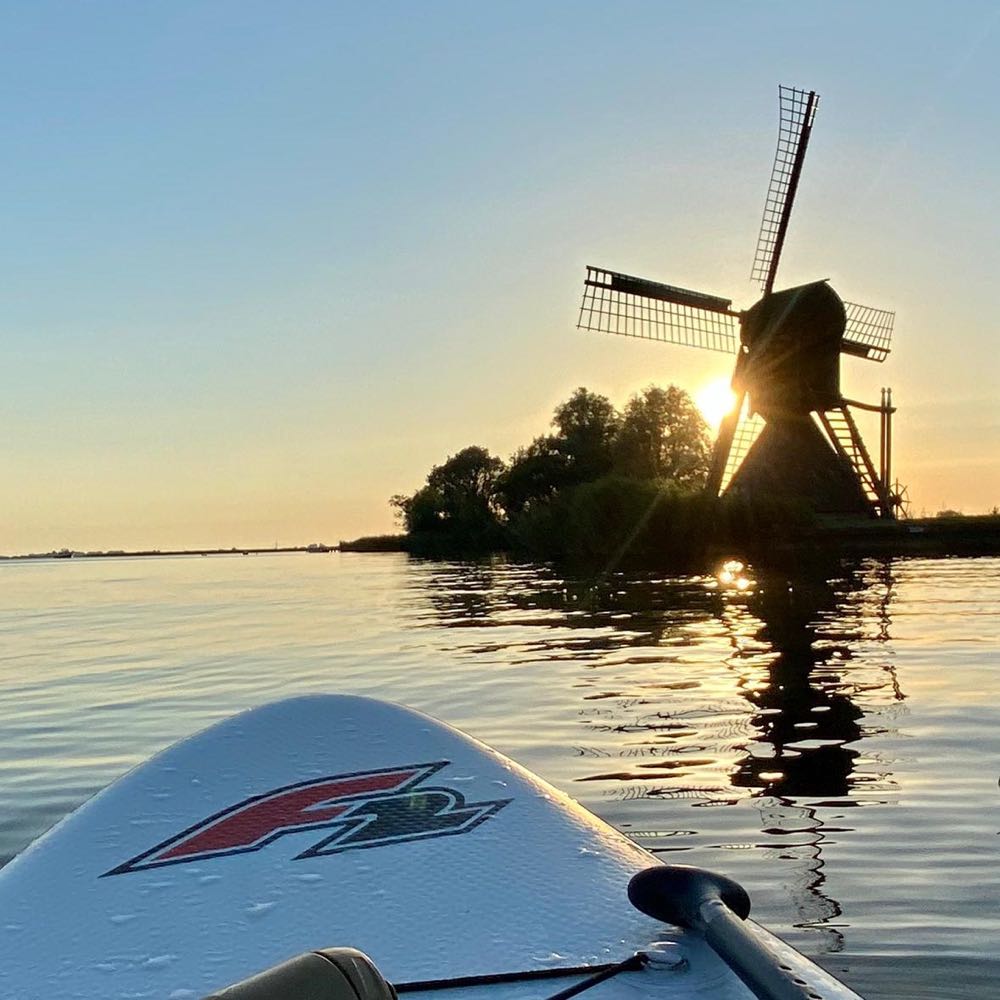 Mühle bei Sonnenaufgang am Wasser