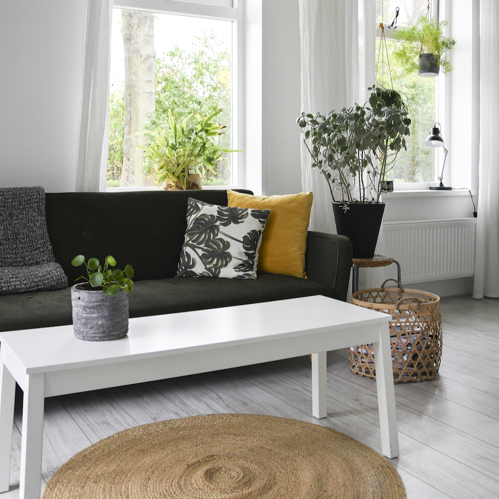 Helles Wohnzimmer mit Sofa, Weidenkorb und Weidenlampe