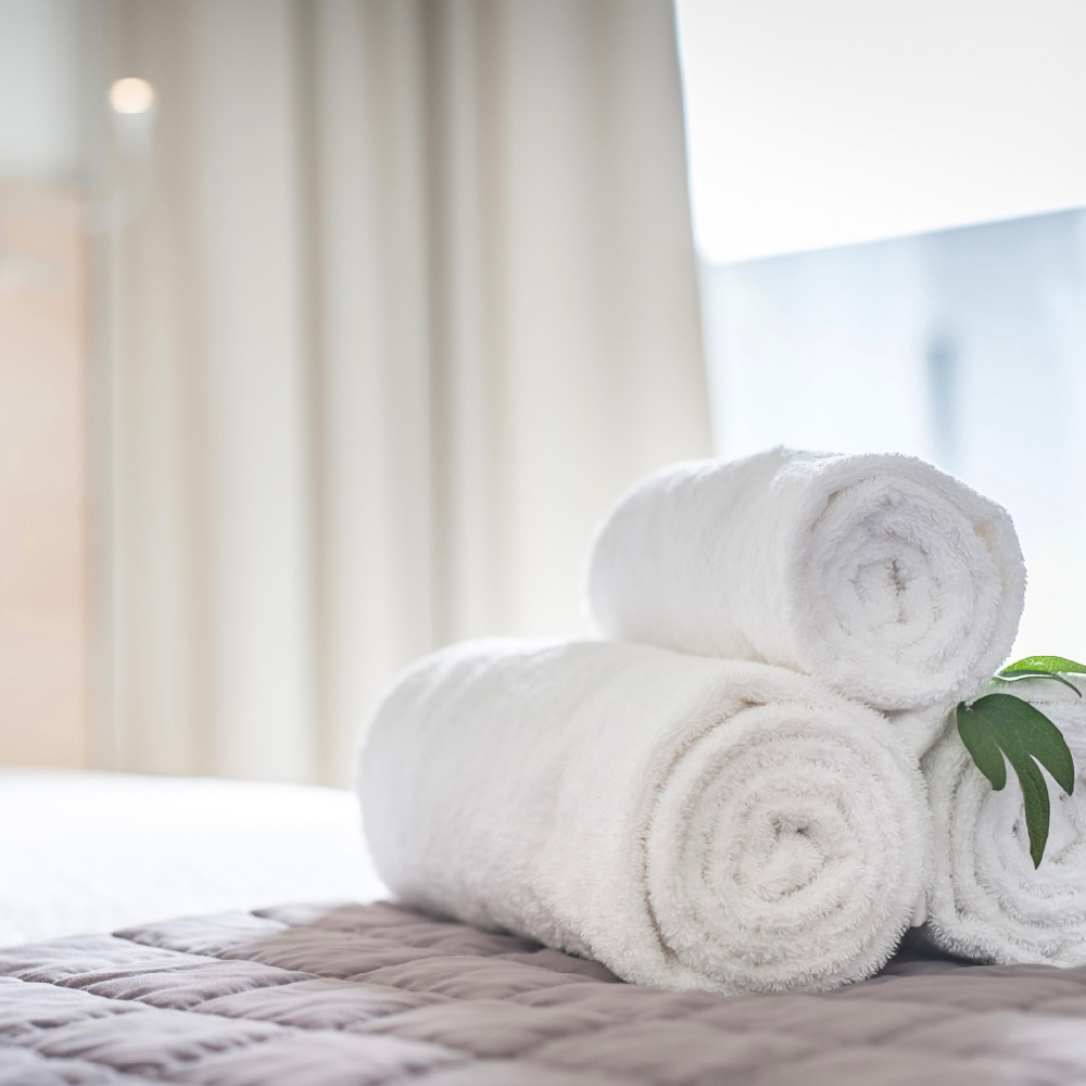 Aufgerollte Handtücher auf dem Bett