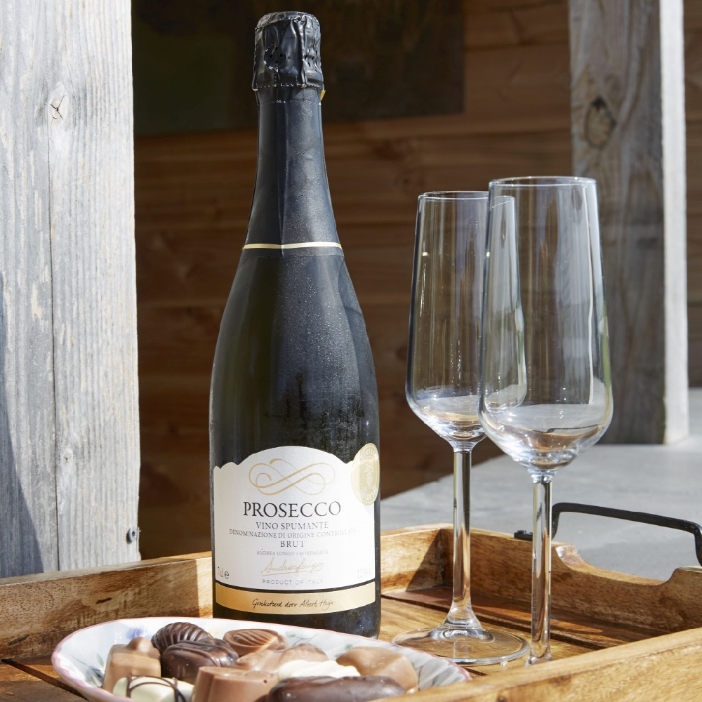Eine Flasche Prosecco mit zwei Gläsern und Schokolade