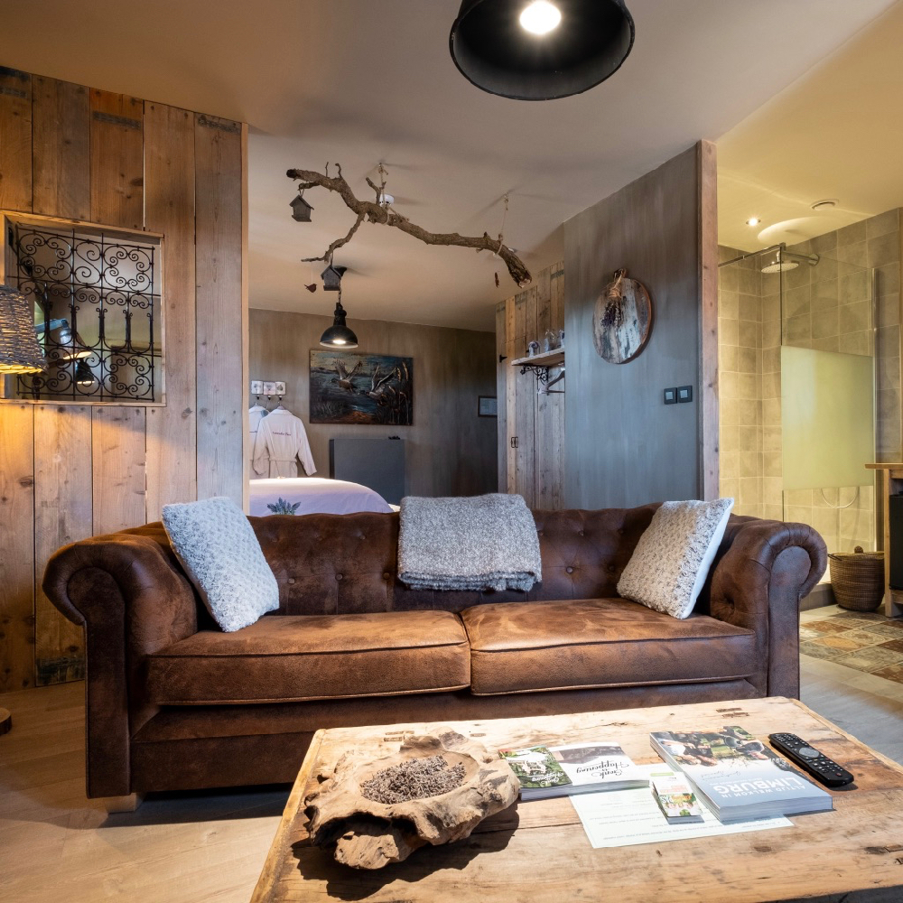 Sitzecke mit Ledersofa in einem Wellness-B&B