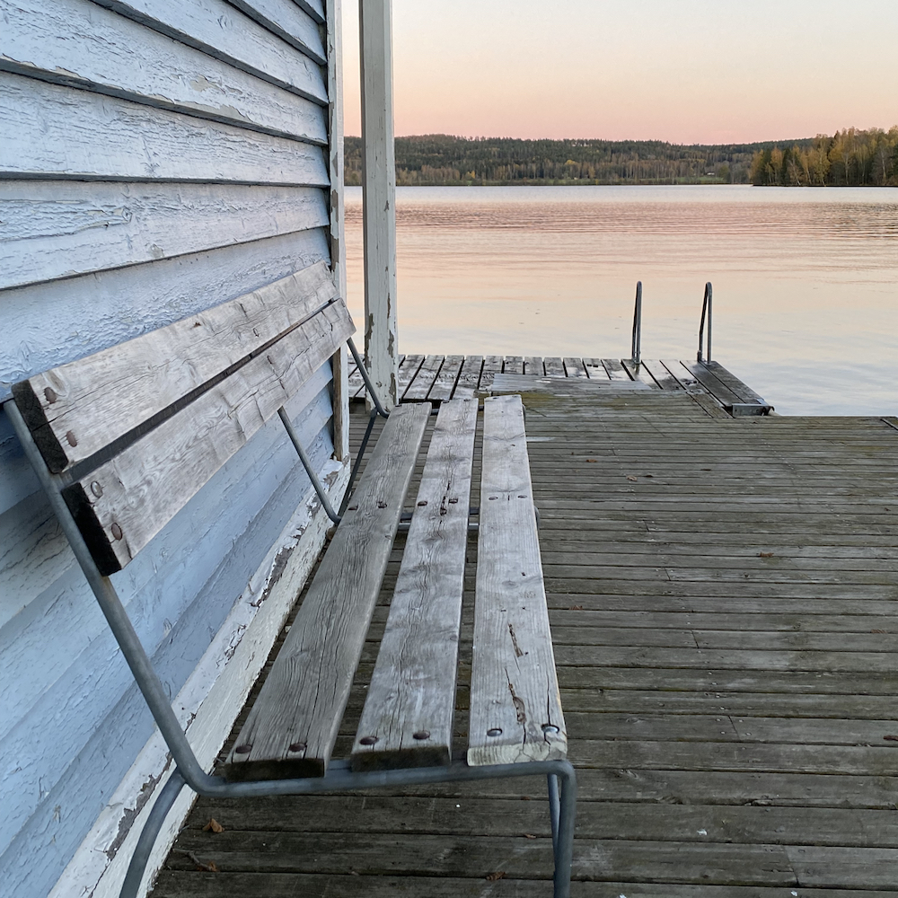 Holzbank auf einem Holzdeck am Wasser