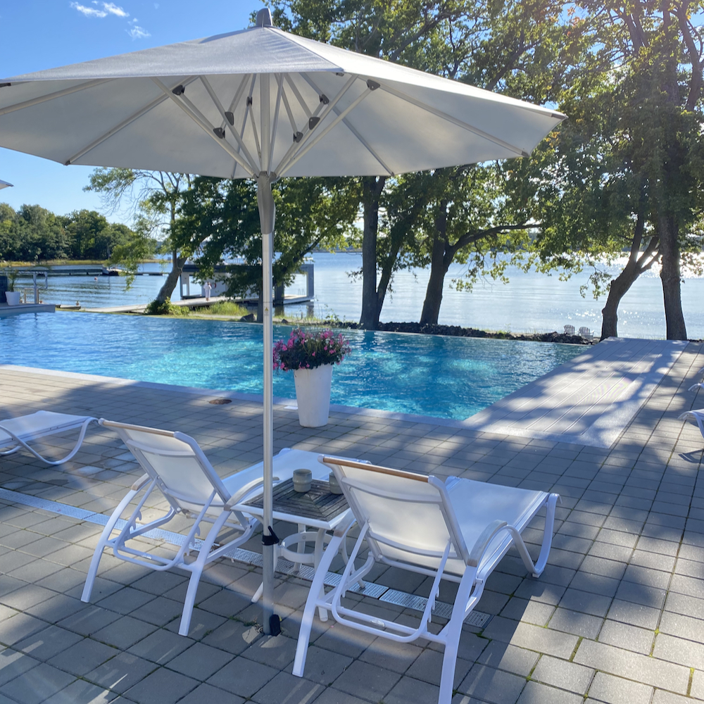 Liegestühle und Sonnenschirm am Pool in Schweden