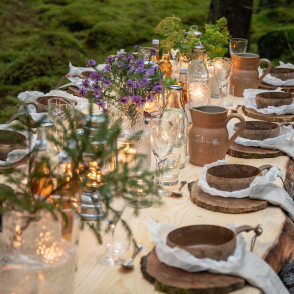 Gemütlich gedeckter Tisch mit schönen Blumenarrangements in Schweden