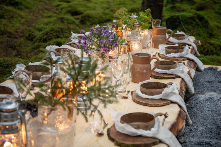 Gemütlich gedeckter Tisch mit schönen Blumenarrangements in Schweden