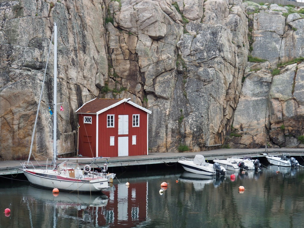 Rotes Holzhaus mit Booten auf dem Wasser