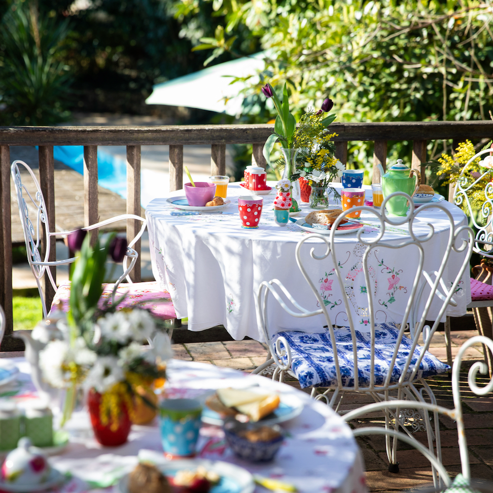 Frühstück auf der Terrasse, buntes Geschirr auf dem Tisch