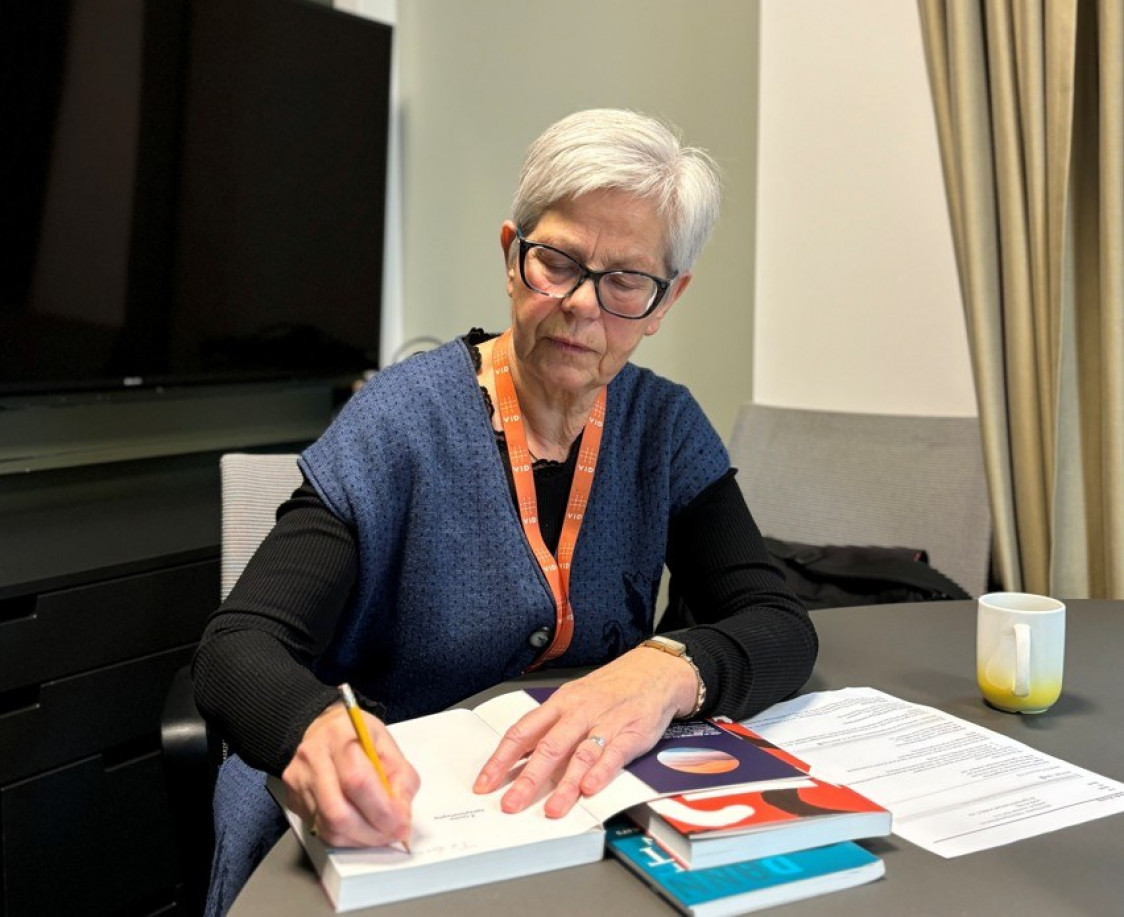 dame sitter og blar i en bok