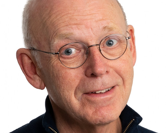Portrettbilde av skallet, eldre og blid mann med briller