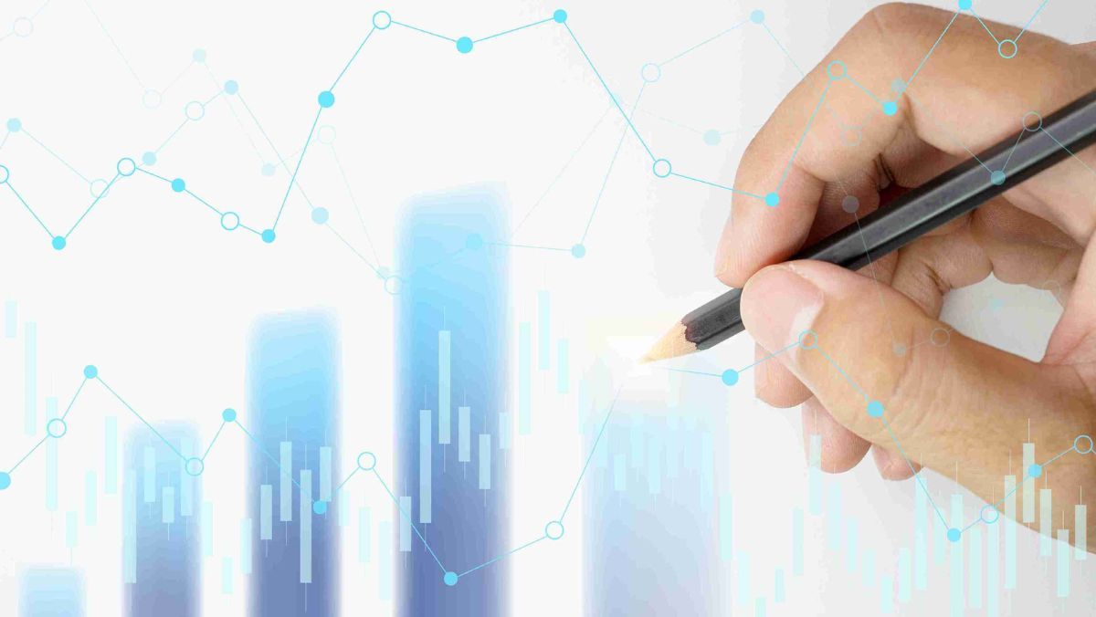 A hand gripping a pencil directs attention to the graphical analysis displayed on the screen