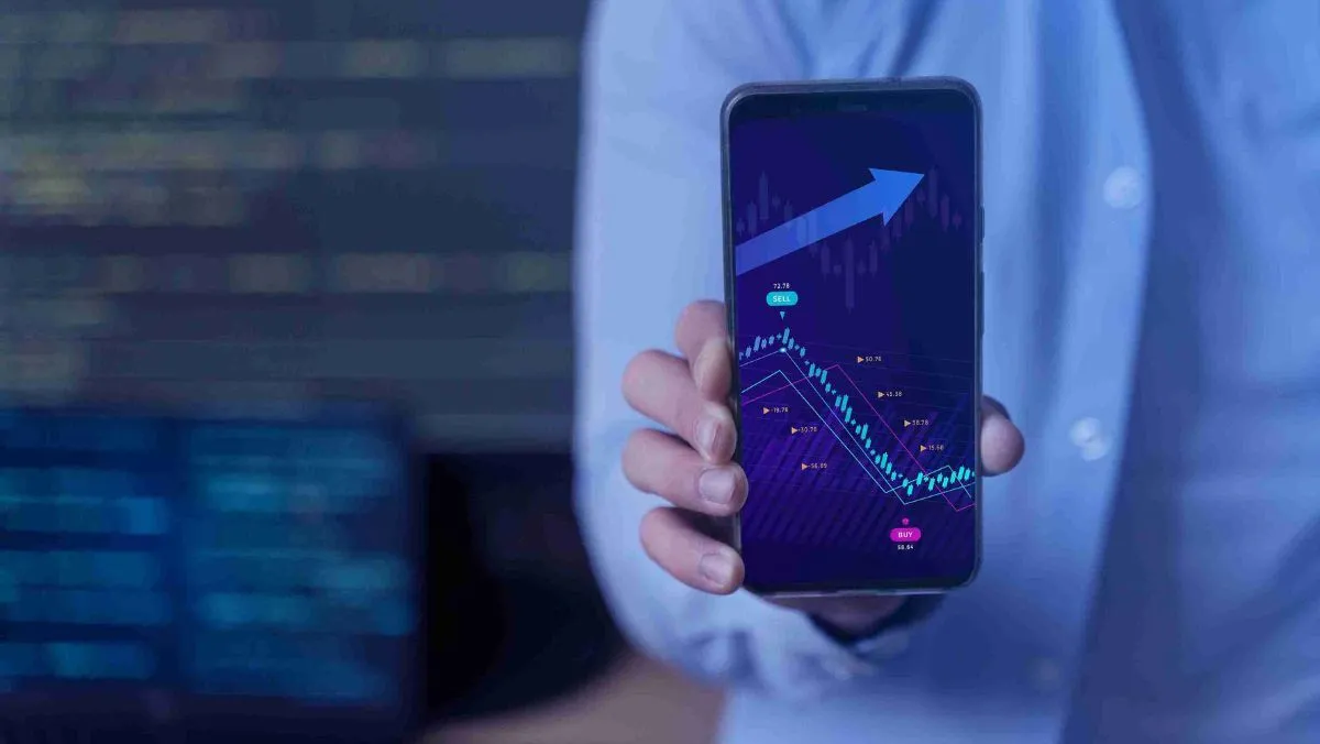 A man presenting a trading chart on the screen of his mobile device