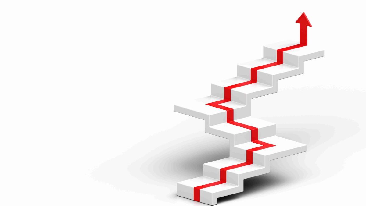 A staircase painted in white with an upward-pointing red arrow affixed to it