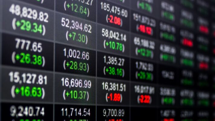 The image shows a blurred stock market display board with numbers