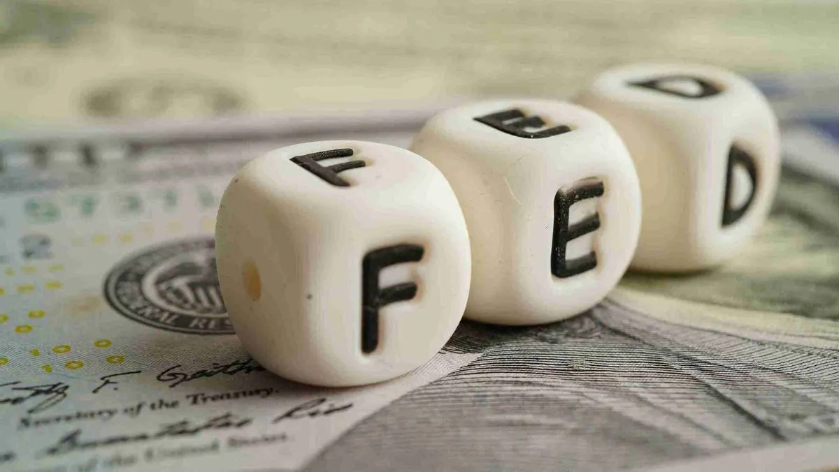 Three white dice bearing the inscription FED resting on a paper currency note