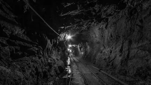 A dimmed gold mining tunnel with railways
