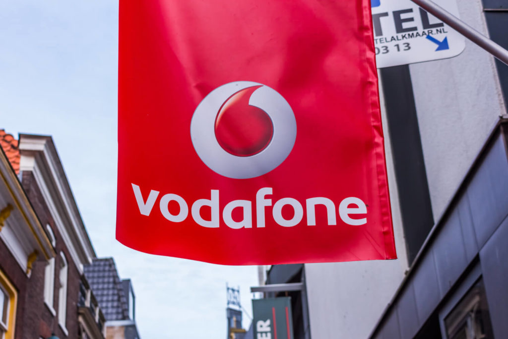 Vodafone logo on a flag hanging outside a mobile phone shop