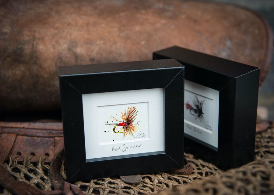 Red Spinner fishing fly frame staged on fishing kit