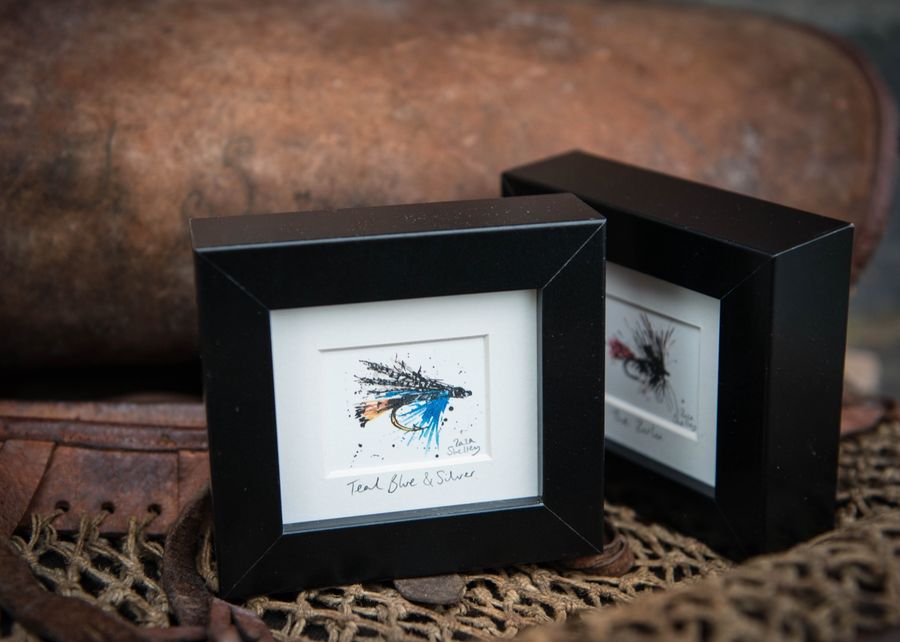 Teal Blue and Silver fishing fly frames on a net